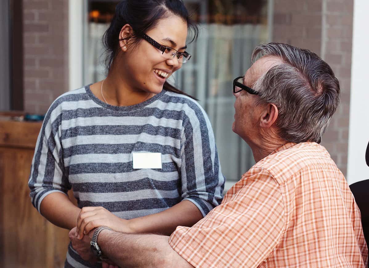 young smiling service worker helping an elderly man